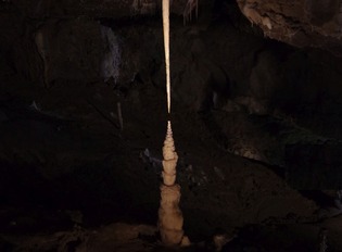 „Romeo i Julia” – para stalaktyt-stalagmit z Jaskini Punkva w Czechach. Obie formy rosną ku sobie, gdy z kapiącej wody wytrąca się węglan wapnia. Ich asymetria – smukły, soplowy stalaktyt u góry i masywniejszy stalagmit u dołu – odzwierciedla różne reżimy kinetyki wytrącania węglanu wapnia. (Fot. Piotr Szymczak)