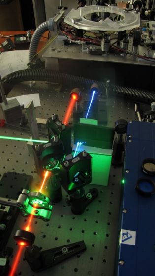 Miniaturowy potrajacz częstości impulsów laserowych (tripler) wytwarza niebieskie i ultrafioletowe impulsy laserowe dzięki przetwarzaniu zogniskowanej wiązki lasera podczerwonego. (Źródło: UW Physics, Radosław Chrapkiewicz)