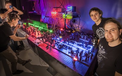 Under certain conditions, two individual, indistinguishable photons will form a pair as a result of interference. This subtle quantum effect has been successfully imaged for the first time by Michał Jachura and Radosław Chrapkiewicz, doctoral students at the UW Faculty of Physics (both shown here, in multiple copies and grouped into pairs on both sides of the measuring apparatus). (Source: UW Physics, R. Chrapkiewicz)